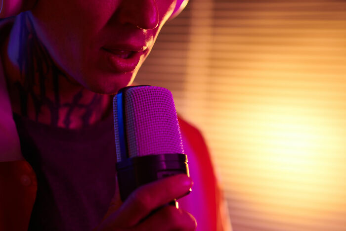 Close-up of person speaking into microphone with dramatic lighting