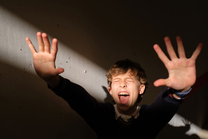 Child screaming and raising hands in a scared haunted house moment