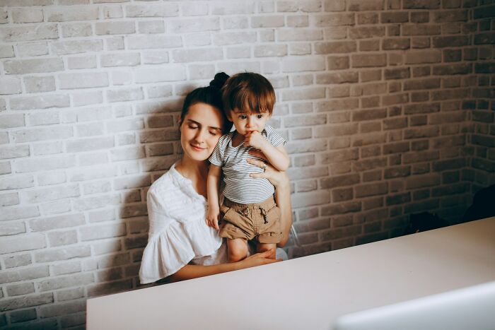 Mother holding toddler smiling after Karen incident