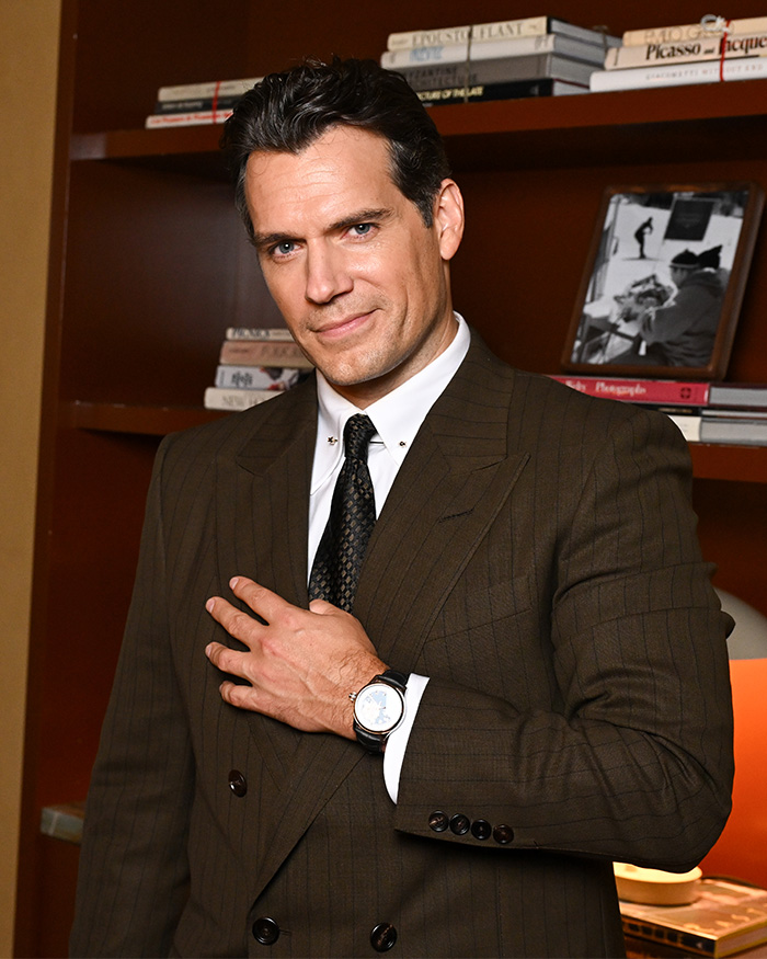 Actor Henry Cavill in a brown pinstripe suit, related to his five-year transformation