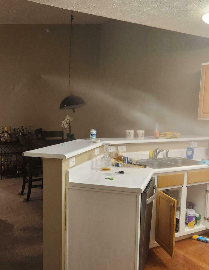 A kitchen with a dusty haze in the air, representing a home renovation mess
