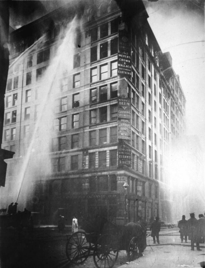 Firefighters spraying water on burning Asch Building, an example of small mistakes leading to disasters