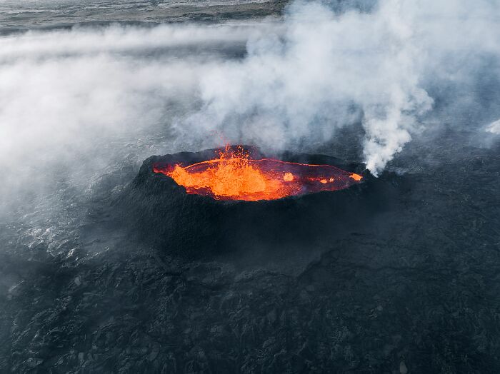 Aerial view of active volcano crater erupting lava, illustrating small mistakes that cause disasters