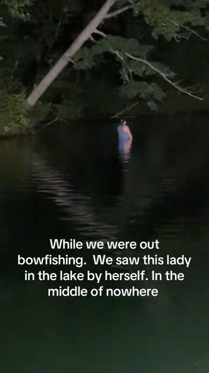 A mysterious figure standing in dark lake water at night, featured in creepy photos.