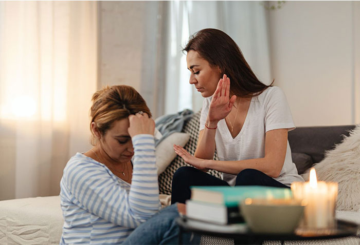 Two female friends talking in a living room, discussing how to test his integrity Two female friends talking in a living room, discussing how to test his integrity