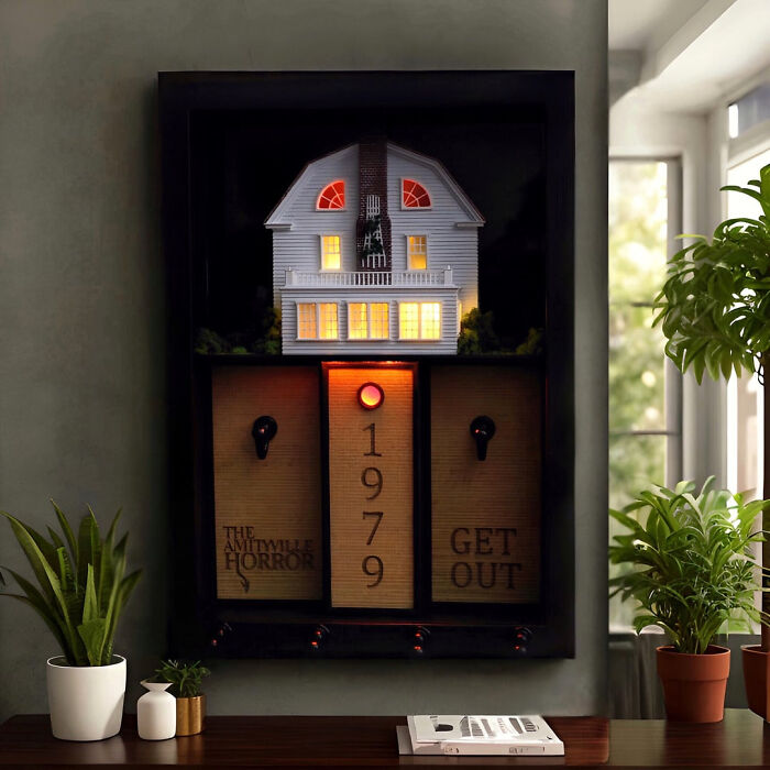 An Amityville Horror miniature house key holder displayed on a wall for spooky Halloween homes.