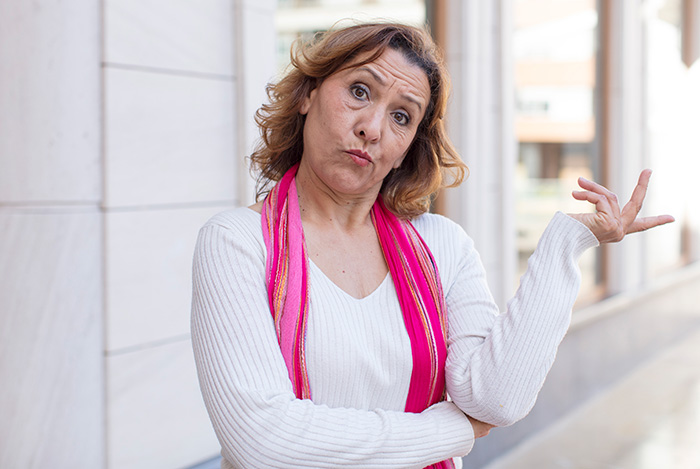 Middle-aged woman making a confused gesture representing a mom looking for a popular costume Middle-aged woman making a confused gesture representing a mom looking for a popular costume