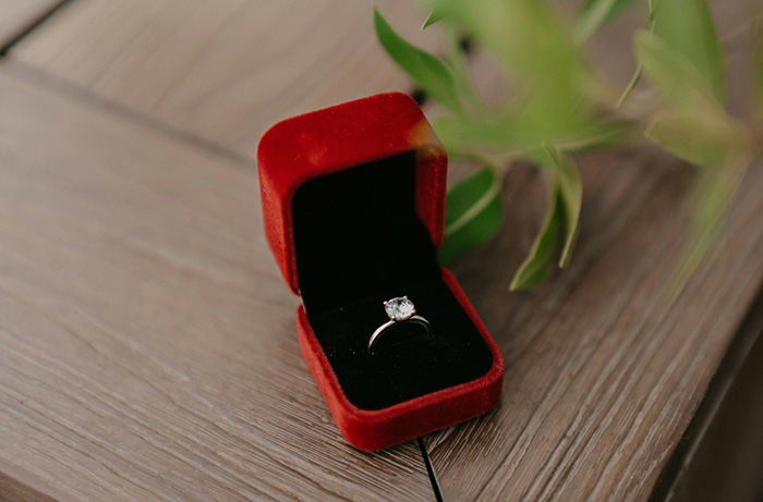 A single solitaire diamond ring inside a red velvet jewelry box representing a family heirloom A single solitaire diamond ring inside a red velvet jewelry box representing a family heirloom