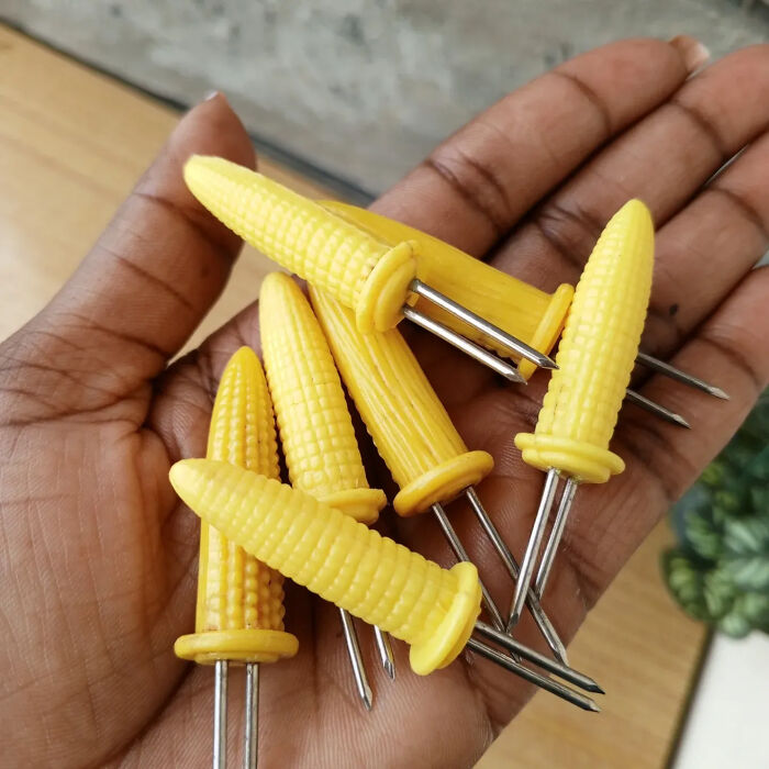 Retro nostalgic corn-shaped corn holders held in a hand