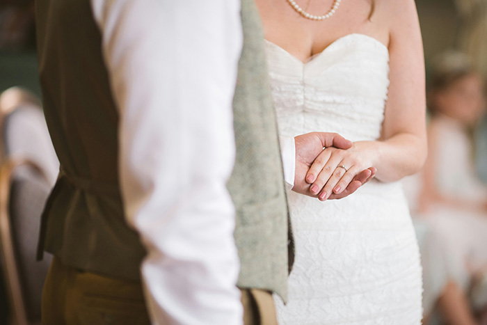 A bride holding hands with the groom, wearing a ring that serves as a family heirloom. A bride holding hands with the groom, wearing a ring that serves as a family heirloom.