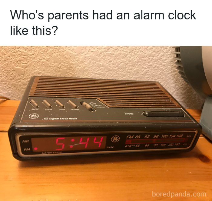 A vintage woodgrain GE digital clock radio showing 5:44, evoking nostalgic memories of retro electronics.