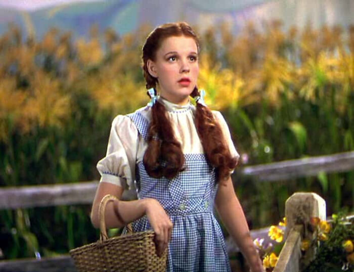 Judy Garland as Dorothy in a gingham dress holding a basket, classic movie props
