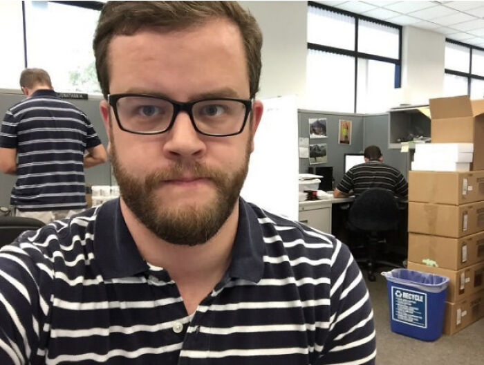 Man wearing glasses and striped shirt with duplicate figure in office glitch