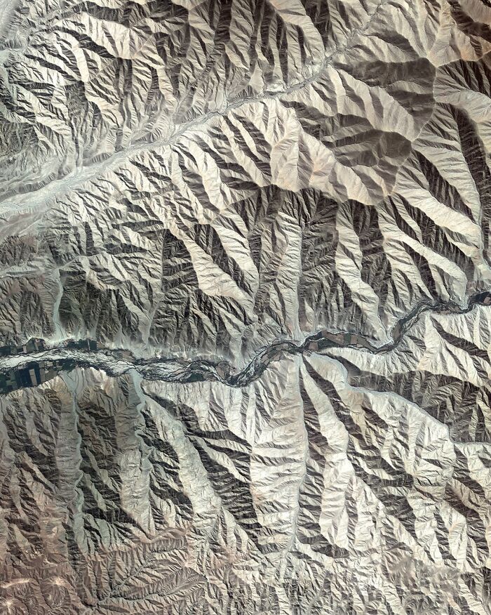 Surreal satellite photo featuring concentric geological rings in a desert landscape.
