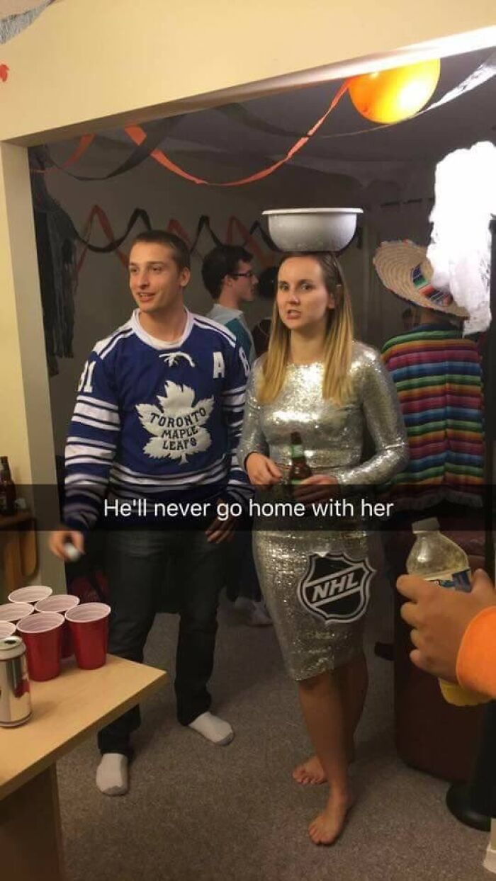 Funny Halloween photo of a woman dressed as a Stanley Cup standing next to a hockey fan