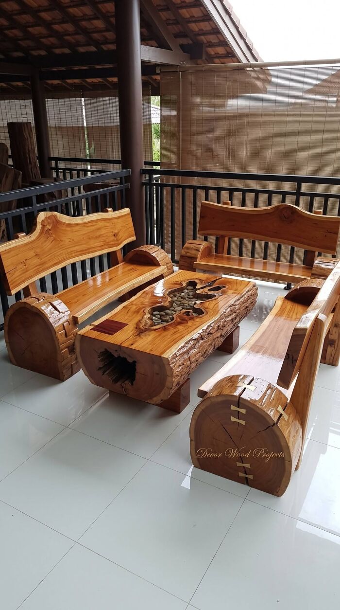 A rustic patio set featuring wooden creations of polished log benches and a matching coffee table.
