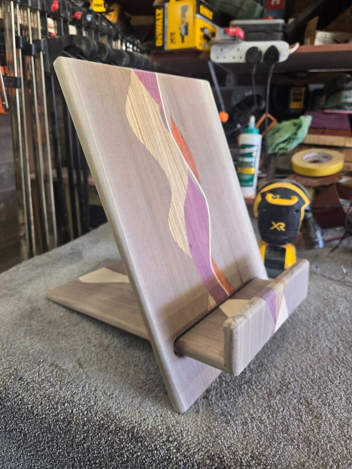 A modern bookrest on a desk, highlighting clever wooden creations with colourful wave patterns