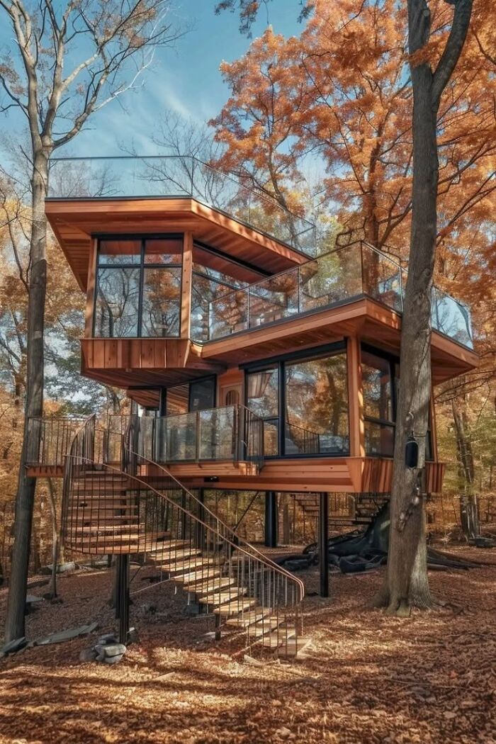 Multi-story modern treehouse with glass railings, demonstrating clever wooden creations in architecture.