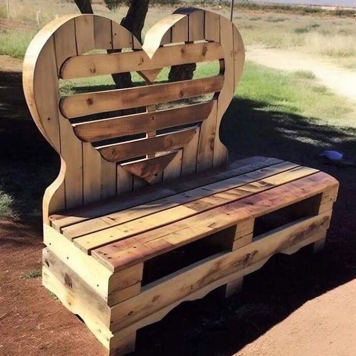 A rustic garden bench made from pallets, showing clever wooden creations shaped like a heart