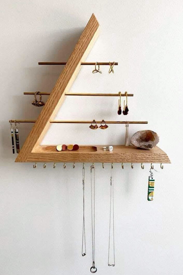 Triangular wooden jewelry organizer on a wall, depicting clever wooden creations