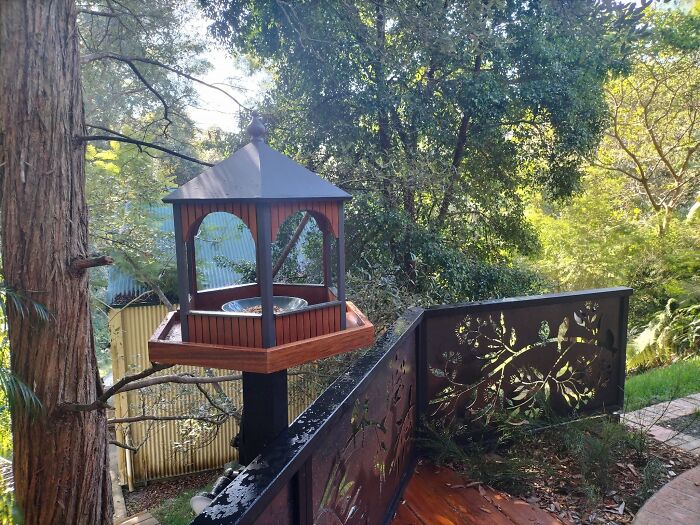 An elaborate birdhouse showing detailed wooden creations on a balcony railing