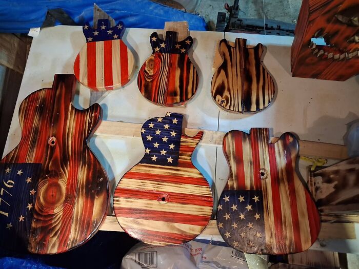 Six guitar-shaped wooden creations decorated with American flag motifs