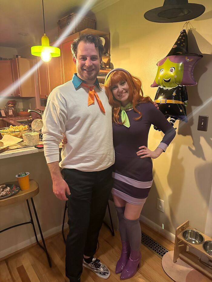 A couple dressed in Scooby-Doo Fred and Daphne funny cool Halloween couples costumes posing indoors