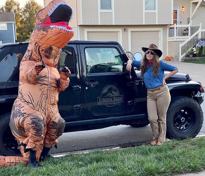 Person in an inflatable T-Rex suit next to someone dressed as a Jurassic Park ranger for funny cool Halloween couples costumes.
