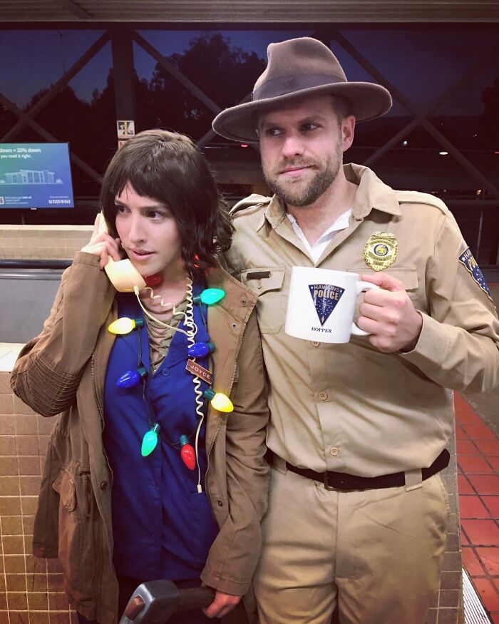 A man in a police officer outfit and a woman wrapped in Christmas lights wear cool Halloween couples costumes