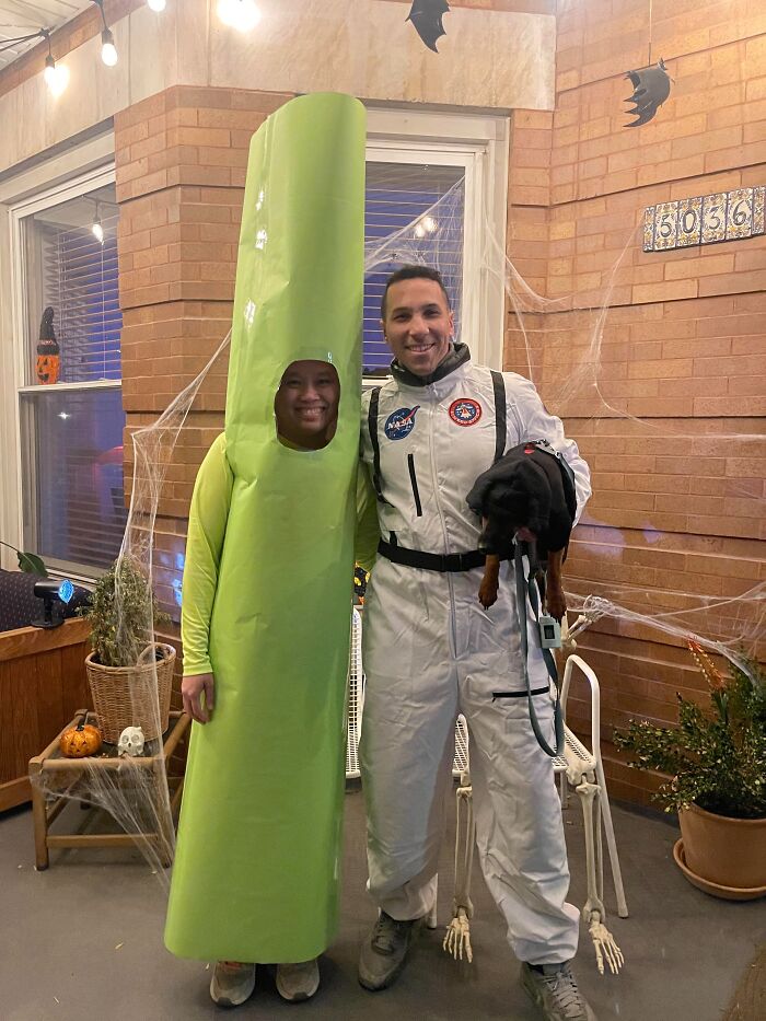 A person dressed as a green stalk and an astronaut standing together as cool Halloween couples costumes