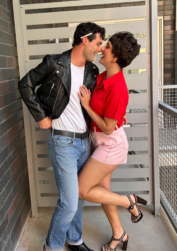 A couple dressed in retro Grease-inspired outfits as funny cool Halloween couples costumes.