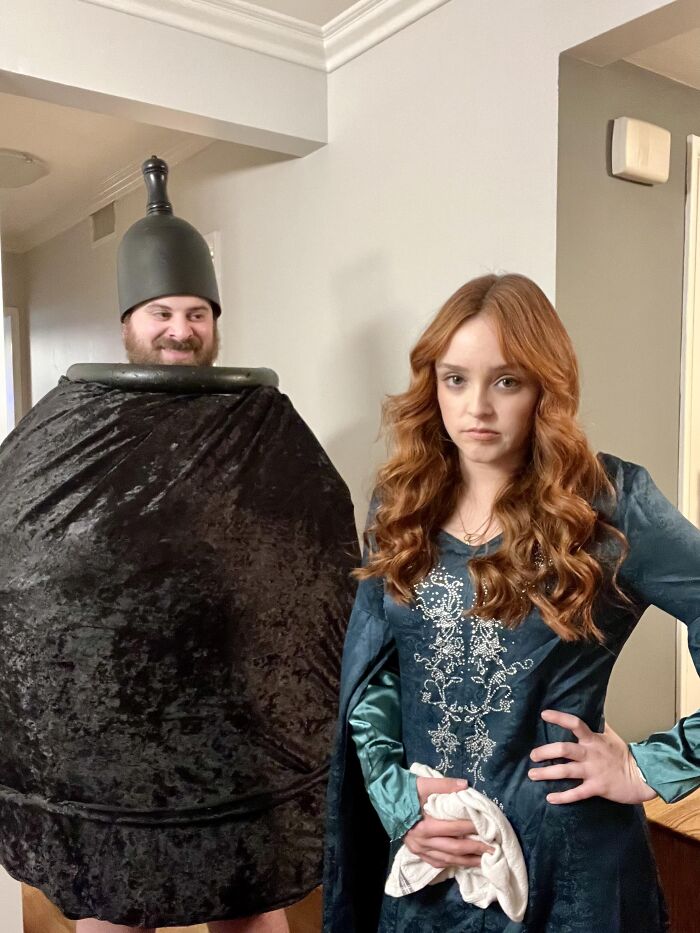 A man dressed as a large urn poses with a woman for funny Halloween couples costumes