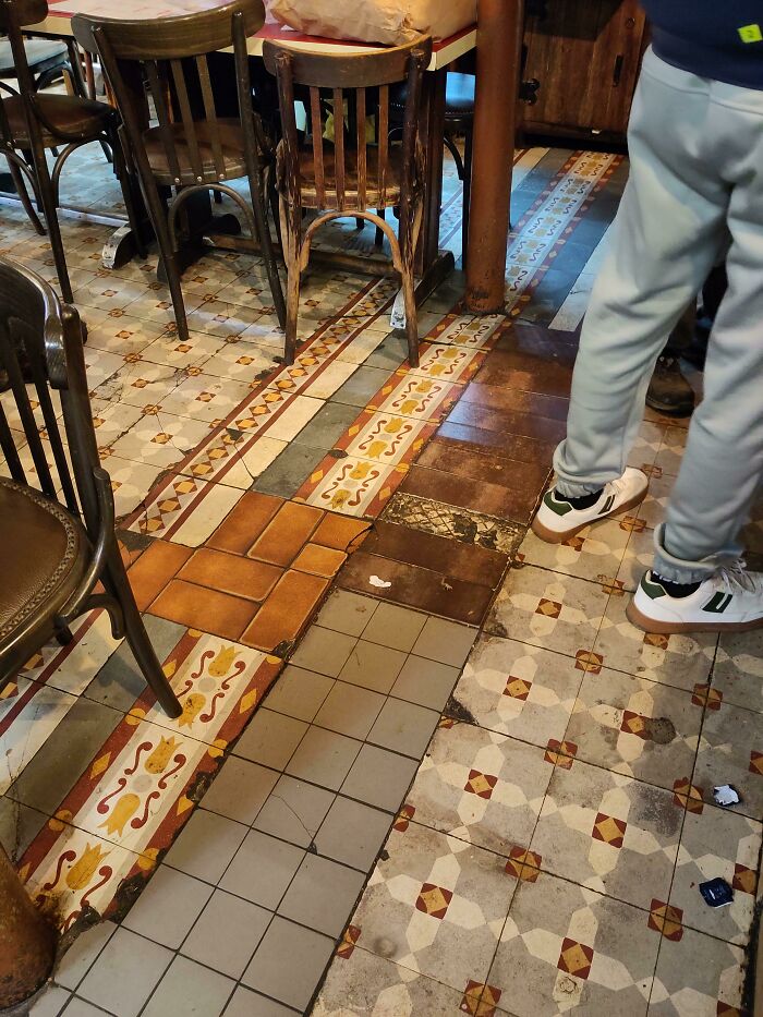 An eclectic floor made from mismatched decorative tiles demonstrating creativity.