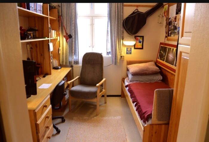 Ingenious things: compact student room featuring a bed, study desk, arm chair, and guitar storage.