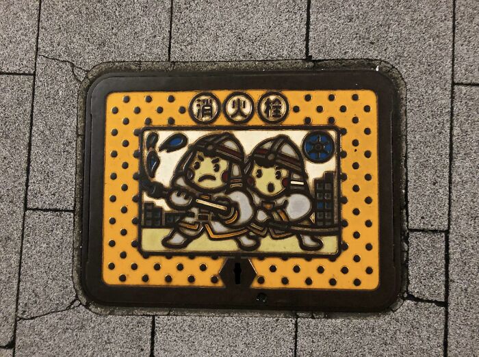 Decorative Japanese manhole cover with firefighter artwork, one of many ingenious things in various parts of the world.