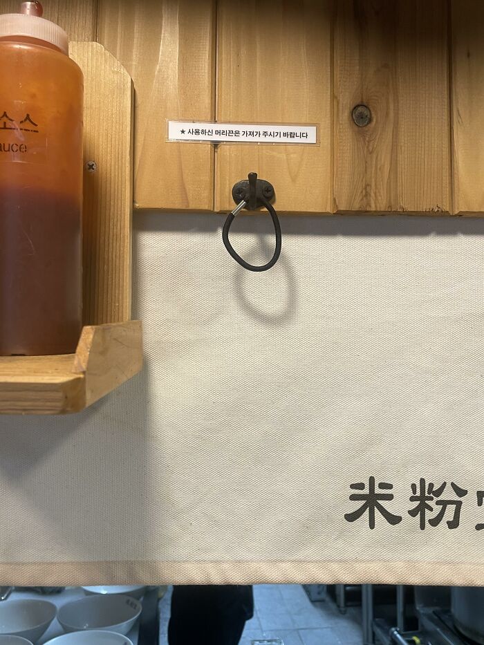 Black hair tie hanging on a wall hook in a restaurant, example of useful things in various parts of the world.
