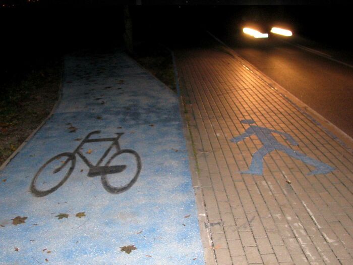 A split sidewalk with painted bike and pedestrian lane icons representing ingenious things in various parts of the world.