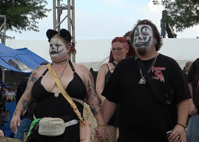 A couple holding hands with clown face paint at The Gathering Of The Juggalos festival