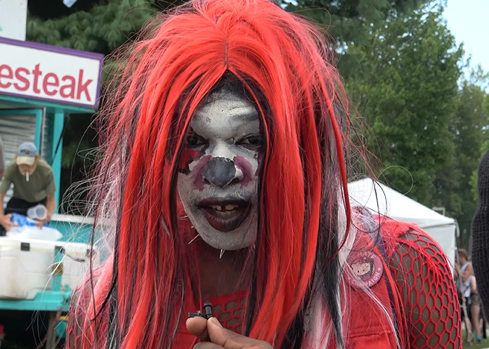 A person with striking red hair and clown face paint at The Gathering Of The Juggalos