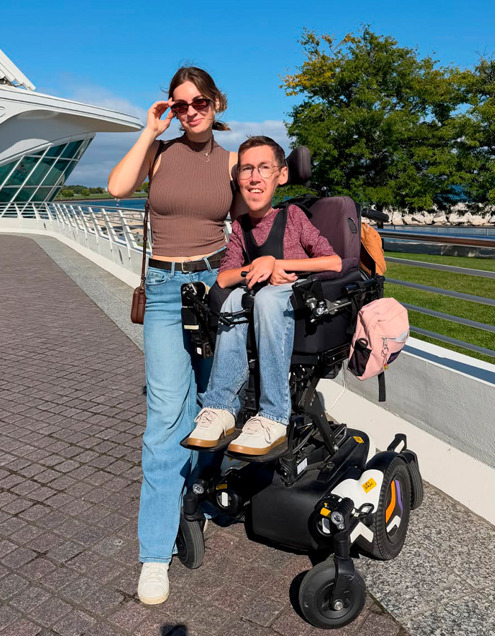Interabled couple standing outdoors together with the husband in a wheelchair Interabled couple standing outdoors together with the husband in a wheelchair