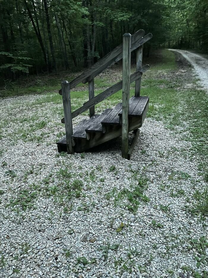 A random set of wooden stairs standing alone outdoors, featured in creepy photos.