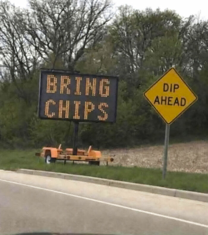 An entertaining sign on the side of the road reading, Bring Chips, next to a Dip Ahead sign.