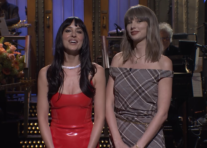 Dakota Johnson and another woman smiling on a TV show stage Dakota Johnson and another woman smiling on a TV show stage