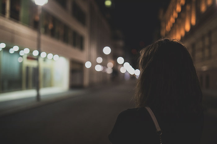 Back view of person walking down empty street at night representing worst-case scenarios