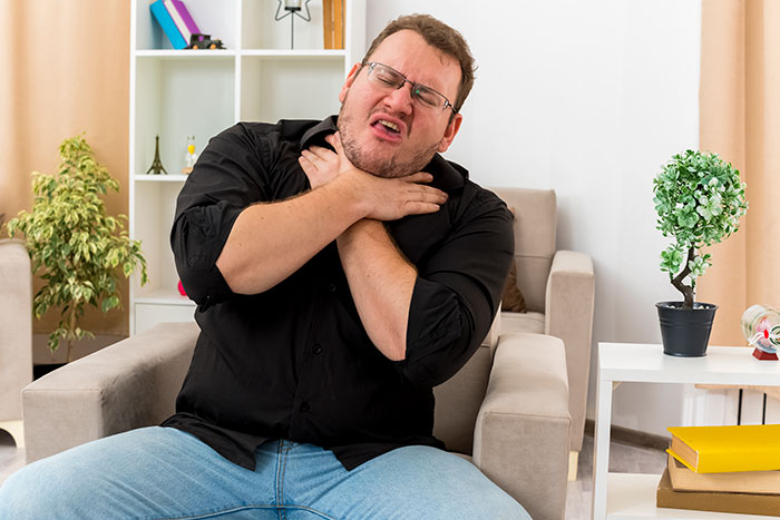 Man clutching his neck in pain from a choking worst-case scenario