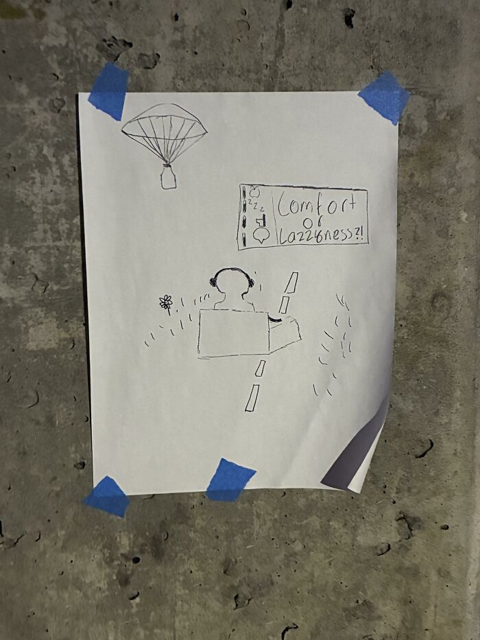 Found paper drawing taped to a wall depicting a figure sitting with a sign about comfort.