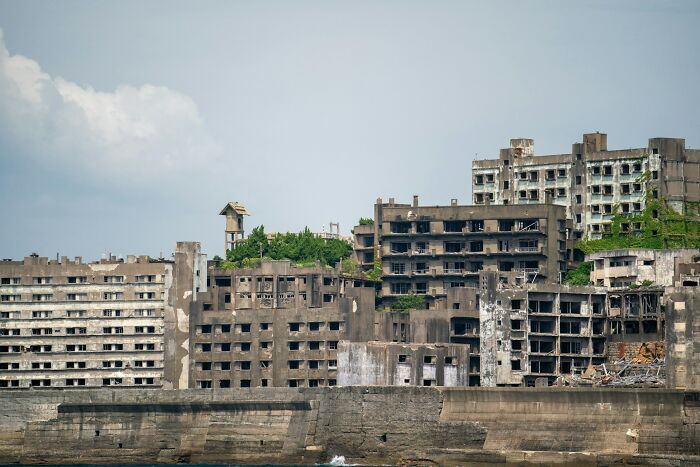 Abandoned concrete buildings on Hashima Island, resembling a post-apocalyptic Hollywood film set.