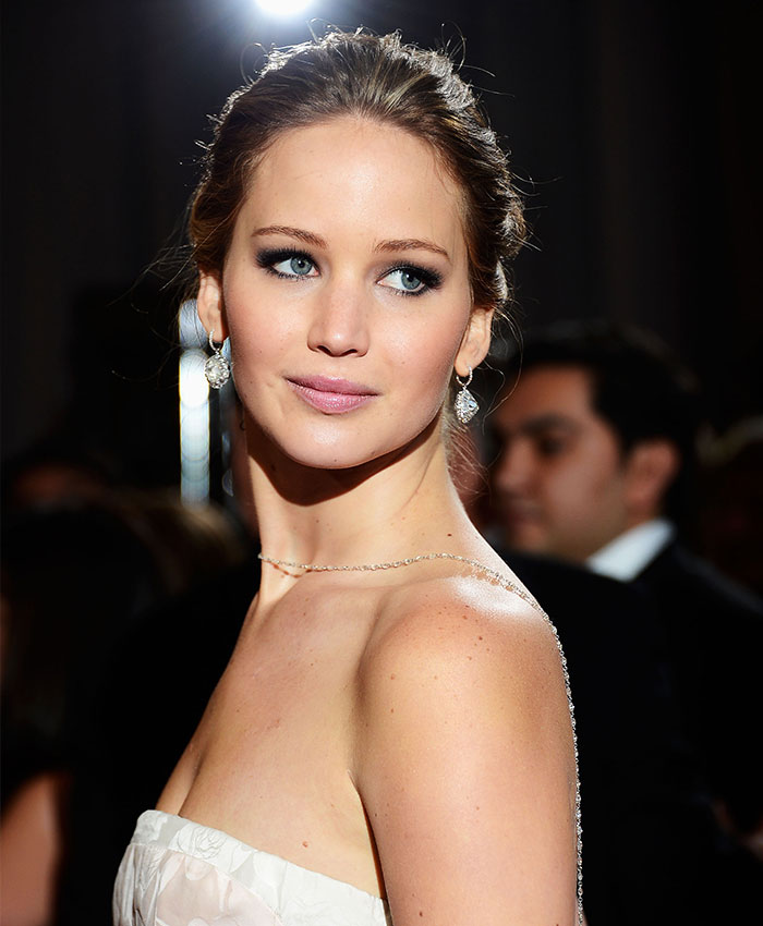 Jennifer Lawrence wearing a white dress at an event, highlighting her classic beauty before plastic surgery talks.
