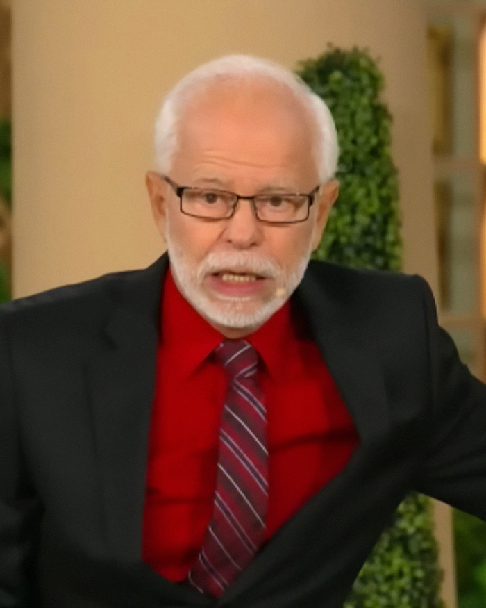 Televangelist Jim Bakker with glasses and white hair speaking in a black suit Televangelist Jim Bakker with glasses and white hair speaking in a black suit