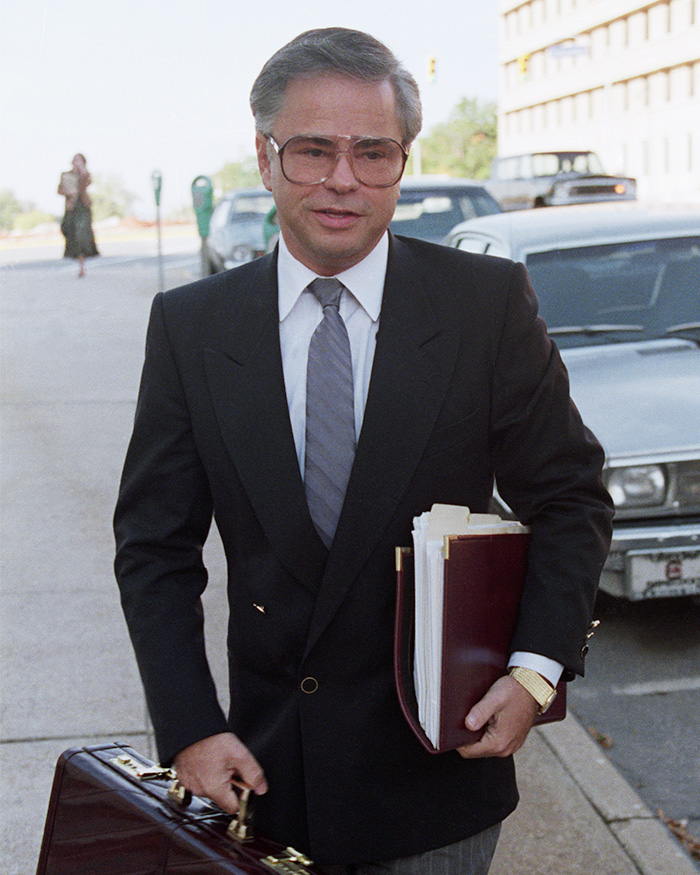 Televangelist Jim Bakker walking with a briefcase and files during a public appearance. Televangelist Jim Bakker walking with a briefcase and files during a public appearance.